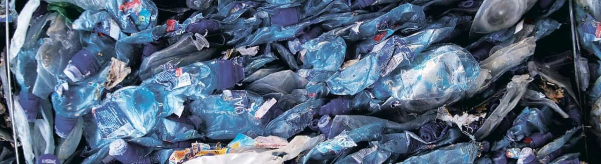 Flatpressede, fargede plastflasker. Foto.