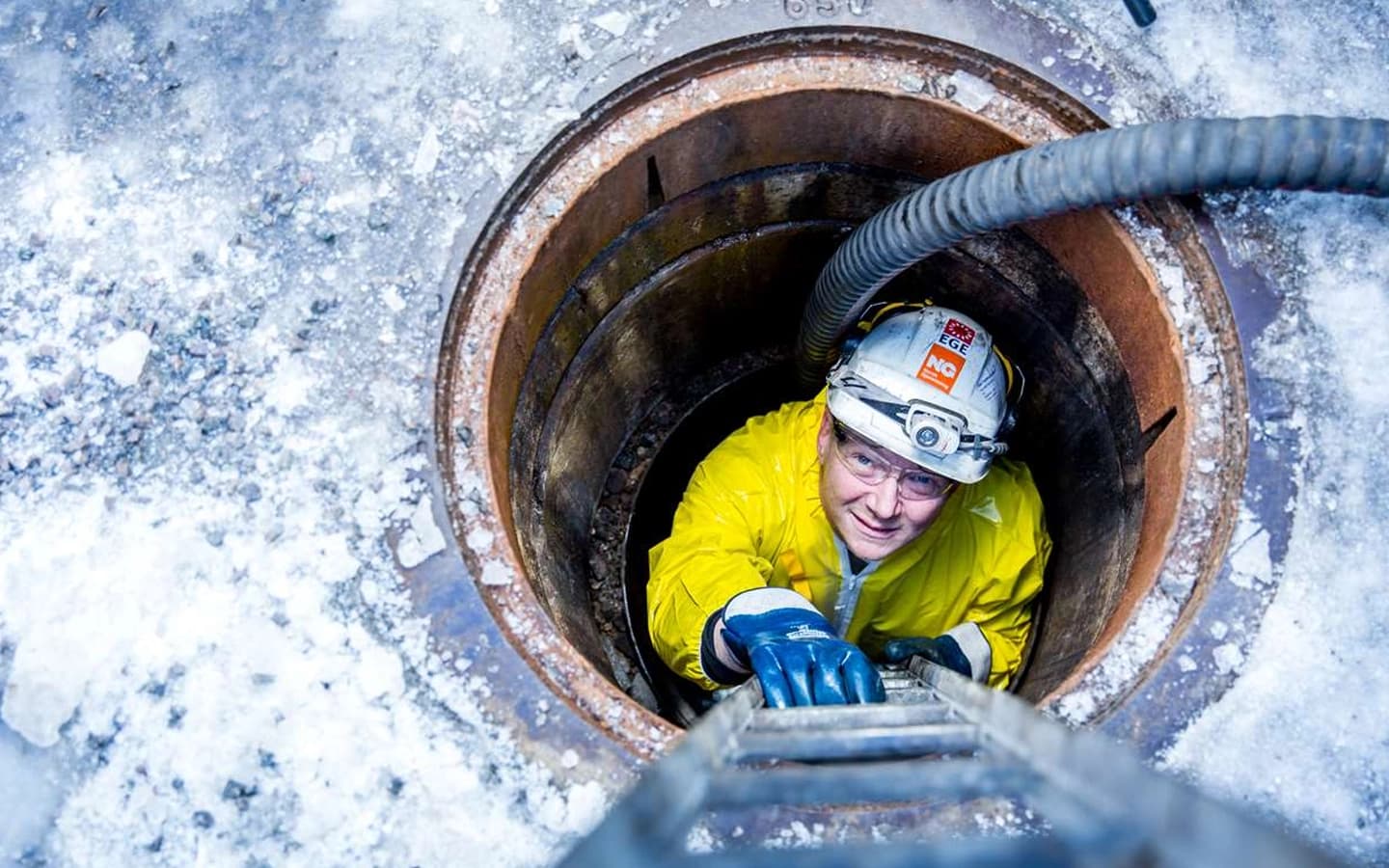 Arbeider som gjennomfører tømming av en septiktank. Foto.