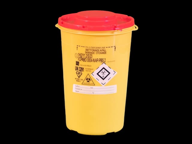 Gul, rund plastboks med rødt lokk. Foto.