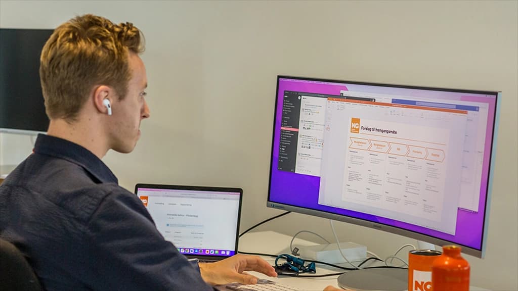 Kontormedarbeider ved PC. Foto.
