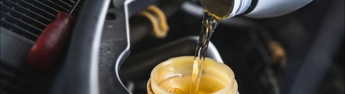 Væske helles fra flaske til beholder. Foto.