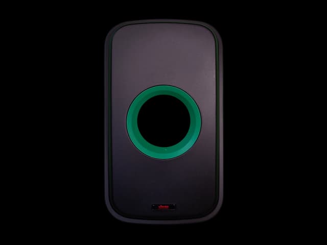 Sort plastlokk med grønt flaskeinnkast. Foto.