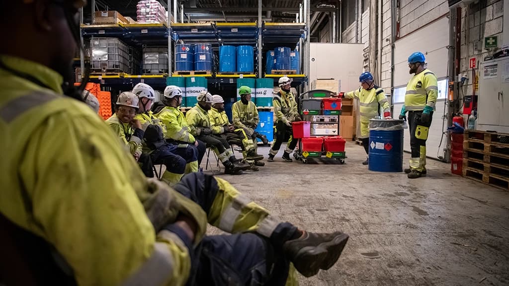Arbeidere sitter sammen og får opplæring på anlegg. Foto.