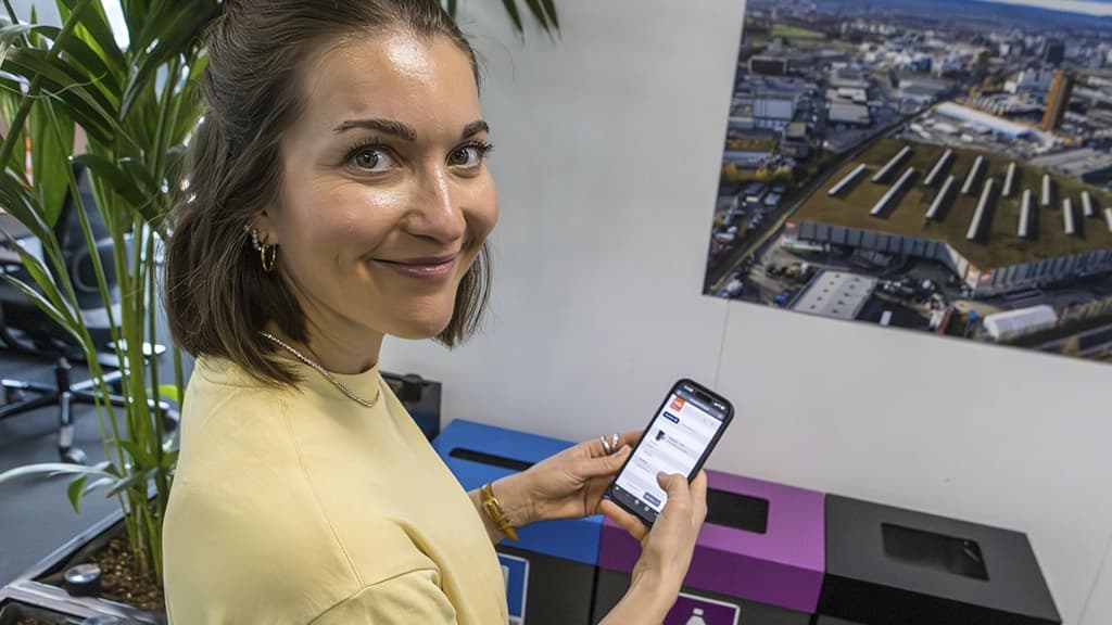 Kontormedarbeider med mobiltelefon. Foto.