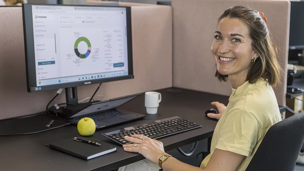 Medarbeider på kontor foran PC. Foto.