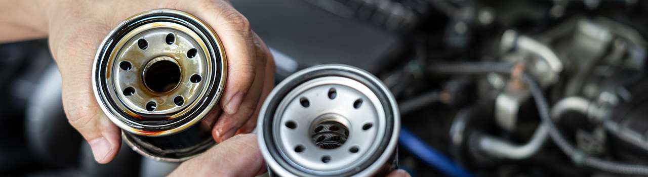 Close up used oil filter in hand a man compare with the new oil filter service concept of oil in the check period